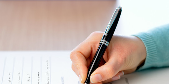 Umfrage Eine Person füllt einen Umfragebogen aus.